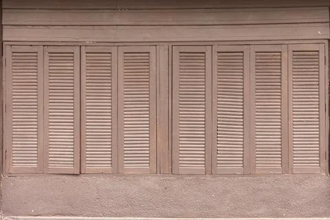 Brown wall of old style windows closed in pattern. Stock Photos