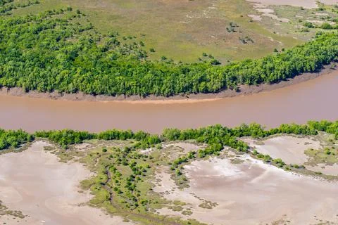Brown water stream through tidal patterns below forming realistic effects f.. Stock Photos