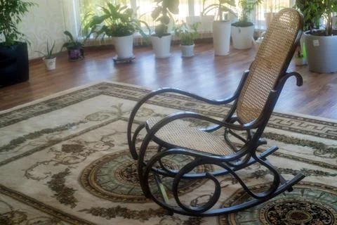 Brown wicker rocking chair in hall Foto stock