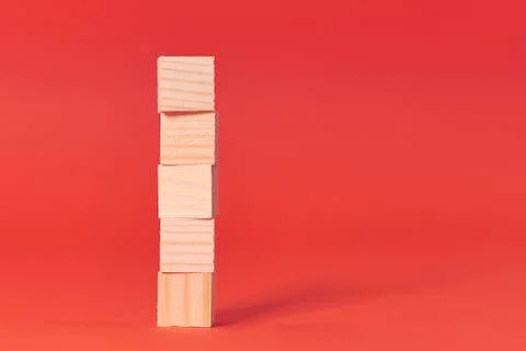 Brown wood bricks tower. construction from wooden cubes. on a red background 写真素材