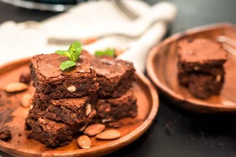 Brownie stack, closeup chocolate cake in plate on rustic wooden table Stock Photos