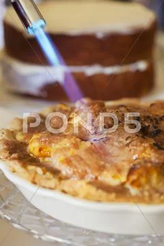 Browning the Top of a Sour Cream Apple Pie with a Kitchen Torch Stock Photos