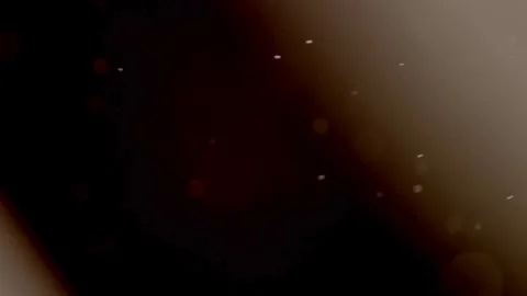 Brownish side light leak illuminates floating tiny dust motes Stock Footage 329598601