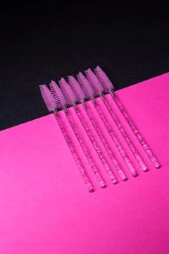Brows brushes sitting on a bright pink surface in a simple arrangement for .. Fotos Stock