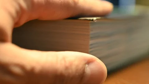 Browsing an angle of a book with thumb of male hand Stock Footage 105129609
