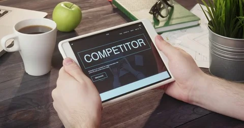 Browsing competitor's web page using digital tablet at desk Stock Footage