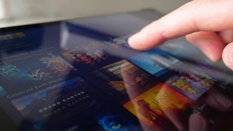 Browsing Disney+ Movies on a Tablet Computer Vídeos de archivo 129311946