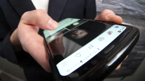 Browsing Facebook app Feed With Posts and Pictures on a Mobile Phone Stock Footage 145494942