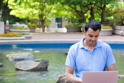 Browsing the laptop by the pond Stock Photos
