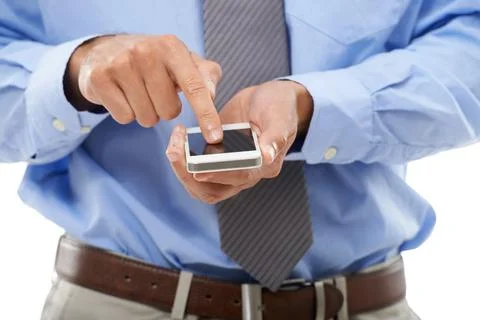 Browsing mobility. Cropped studio shot of a young businessman using a cellphone Stock Photos