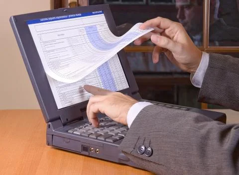 Browsing the pages with technical data sheets on computer Stock Photos