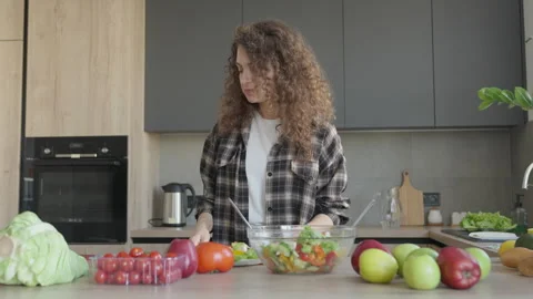 Browsing Recipe On Phone While Cooking Fresh Salad In Cozy Kitchen Setting Stockbeeldmateriaal 311270410