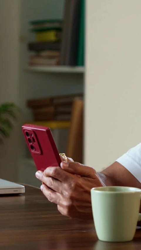 Browsing smartphone at breakfast, stylish Indian mid age man in modern kitchen Stock Footage 342756763