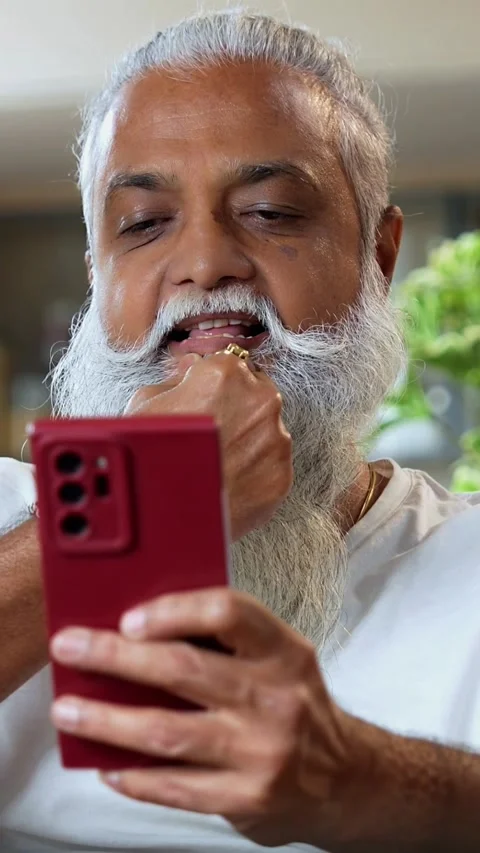 Browsing smartphone at breakfast, stylish Indian mid age man in modern kitchen Stock Footage 342756774