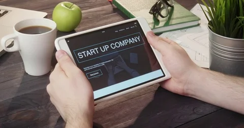 Browsing start up company landing page using tablet computer at desk Stock Footage