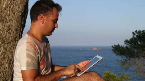 Browsing Tablet Next to the Sea Video stock 40906473