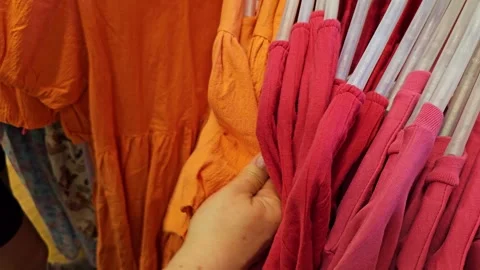 Browsing through clothes on racks in a clothing store Stock Footage 321533238