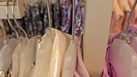 Browsing through clothes on racks in a clothing store Stock Footage 321533242