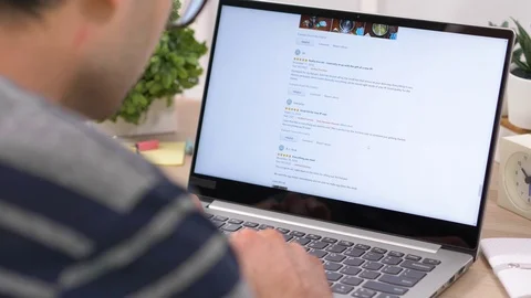Browsing User Reviews Online on a Laptop Computer Stock Footage