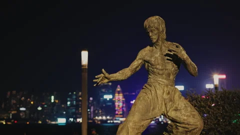 Bruce Lee statue in fighting position on night avenue of stars in Hong Kong Stock Footage 319013980