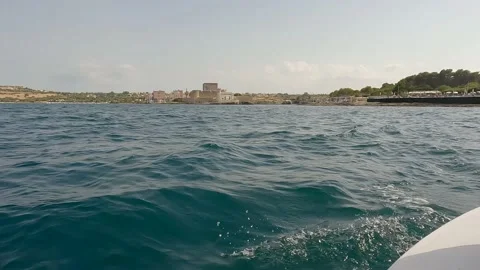 Brucoli castle lighthouse seen while sailing in a small sailboat on a sunny day. 库存影片 239324891