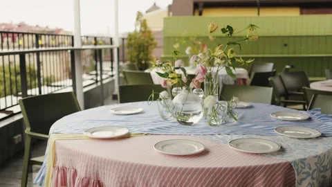 Brunch table with plates and vase gingham and floral linens layered chargers Stock-Footage 325844170