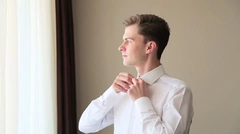 Brunete man buttoning white shirt Stock Footage 64916897