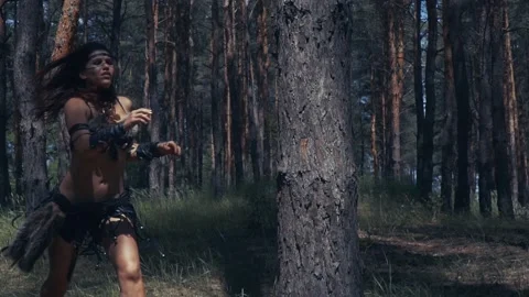 Brunette amazon runs up to the tree in the forest, slow motion Stock Footage 138423887