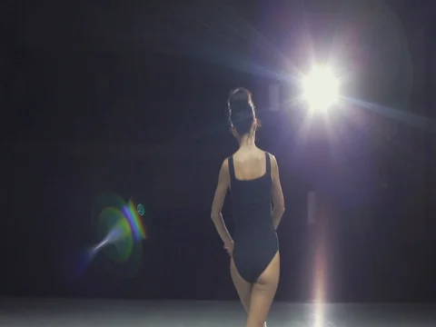 Brunette ballerina dancing on an empty stage in front of rays of light 1 Video stock 80495862