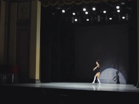 Brunette ballerina dancing on an empty stage in spotlight 2 Video stock 80500556