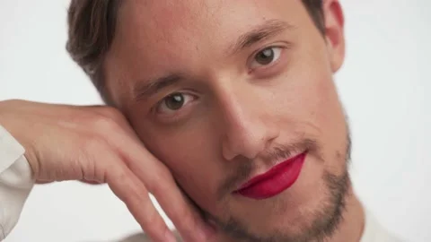 Brunette bearded guy with painted lips gently stroke soft skin of face with hand Stock Footage 147571888