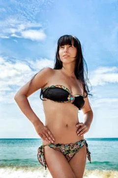 Brunette beautiful model posing on a beach Stock Photos