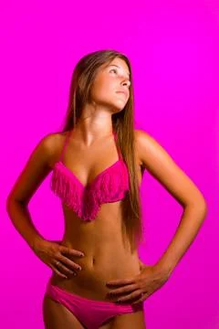 Brunette in bikini posing on pink background Stock Photos