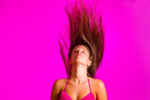 Brunette in bikini posing on pink background Stock Photos