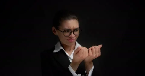 Brunette with a dissatisfied expression looks at hands, does not like manicure Stock Footage 193396444