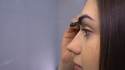 Brunette doing eyebrows makeup close up in profile Stock Footage 74938690