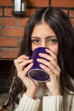 Brunette drinks tea from a mug Stock Photos