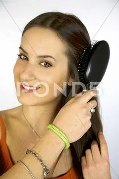 Brunette female model brushing long hair Stock Photos