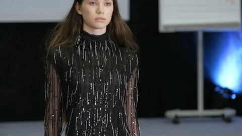 Brunette female model walk on podium. Girl in black dress with fringe pattern. Stock Footage