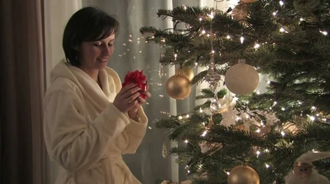 Brunette finding a present under a Christmas tree Video stock 11828953