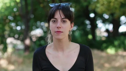 Brunette girl counts down from five at the park Stock Footage 291655120