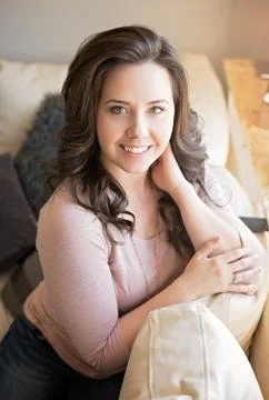 Brunette Girl Smiling on Couch Stock Photos