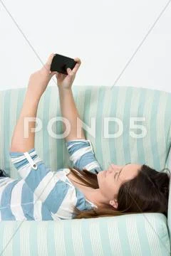 Brunette girl using a smartphone Stock Photos