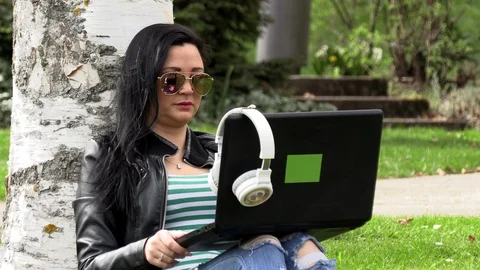 Brunette on the grass with a computer Stockbeeldmateriaal 107001199