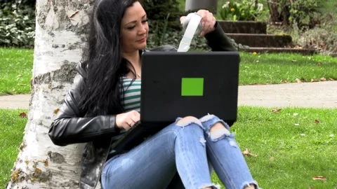 Brunette on the grass with a computer Video stock 107034664