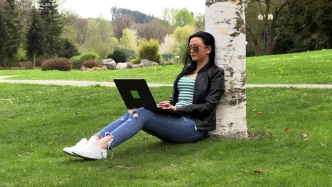 Brunette on the grass with a computer Stock Footage 107068864