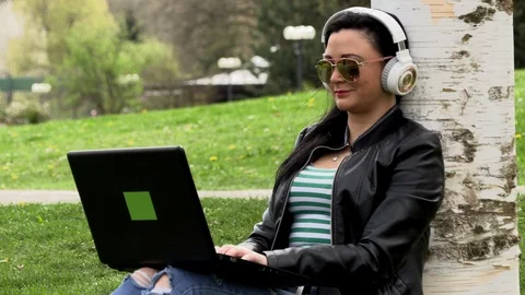 Brunette on the grass with a computer 库存影片 107068964