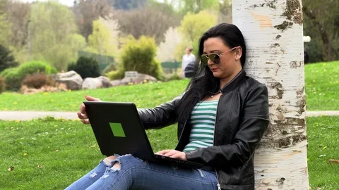 Brunette on the grass with a computer Stock Footage 107072109