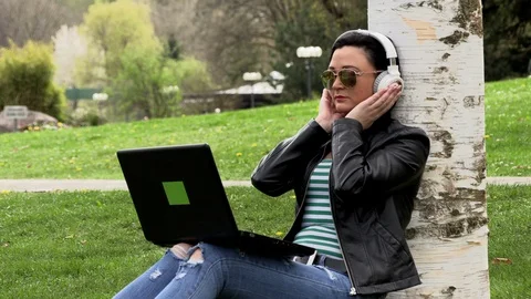 Brunette on the grass with a computer 库存影片 107072972