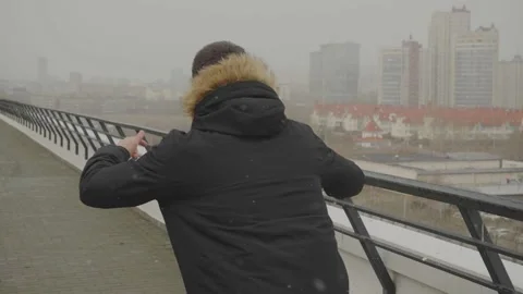 The brunette guy dances on the terrace feeling free. Shooting from behind Stock Footage 134133624